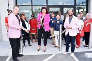 Christina Rader, center, Helberg Diamonds Store Manager, cuts the ribbon at her store's new location outside Independence Center, in Independence, Mo.