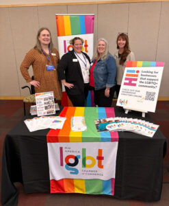 Joy Hope, left, Jene' Lamb, Jessica Mumma, and Kira Johnston-Owens pose at the Mid-America LGBT Chamber of Commerce table at the Prospect Business Association 2nd Annual Small Business Expo, held Friday, Oct. 25, 2024, at the Kauffman Foundation Center in Kansas City, Mo.