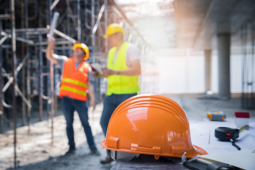 istockphoto-1342202072-170667a The yellow safety helmet in construction site and construction site worker background safety first concept.