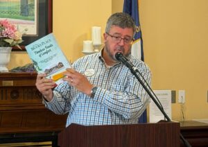 Tim, Director at Brooks Place holding the Rose Mary C Brooks Cook Book