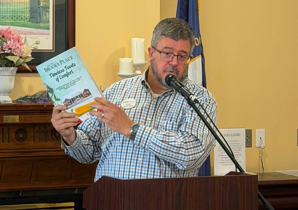 Tim, Director at Brooks Place holding the Rose Mary C Brooks Cook Book