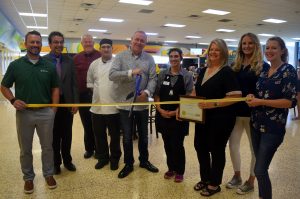Mikey Gauna, center, food service director for Aladdin Campus Dining, cuts the ribbon as his business is welcomed as the newest Logan County Chamber of Commerce member Wednesday, Aug. 24, 2022. Joining him are Aladdin staff, Chamber ambassadors Brock Baseggio, Caitlin Baseggio and Brianna McBride, along with Glenna Phelps-Aurich, third from right, executive director of the Chamber. (Callie Jones/Sterling Journal-Advocate)
