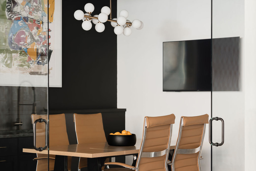 meeting space with monitor, table, and chairs