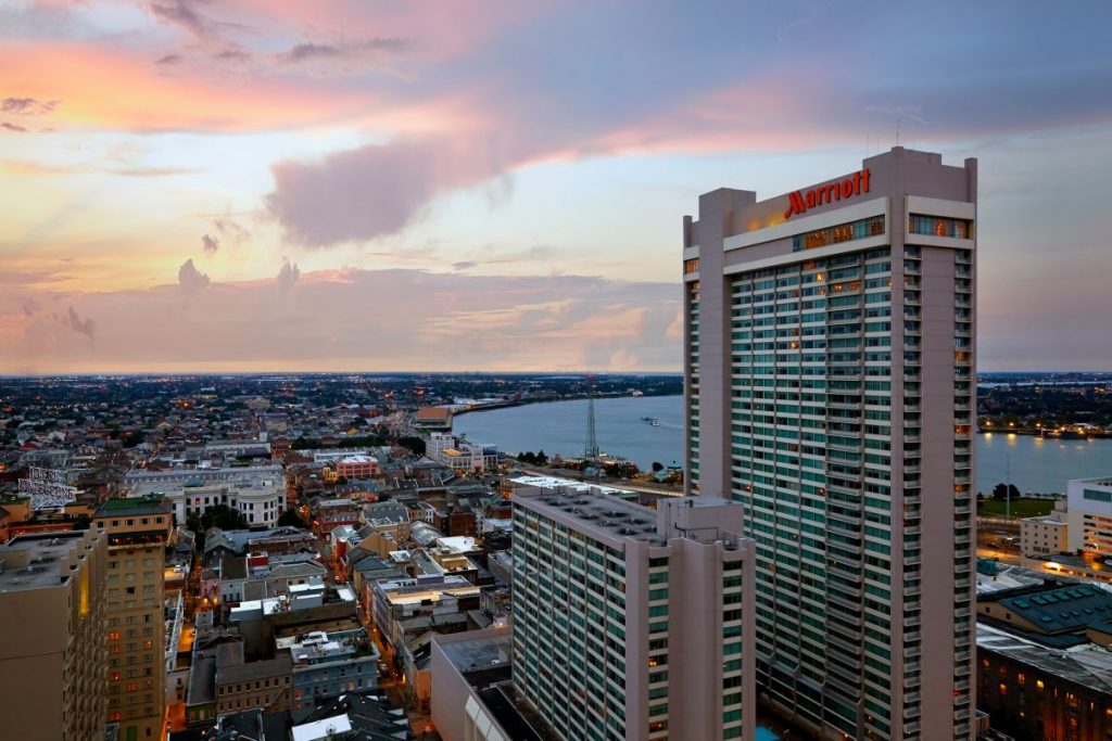 Photo of New Orleans Marriott&#039;s two towers, exterior view at sunset and Mississippi River and other downtown buildings in background.