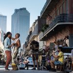 Two people are dancing in the street in front of buskers in New Orleans.