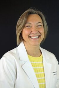 Jonette Owen headshot, women with above shoulder length hair, white labo coat and yellow shirt