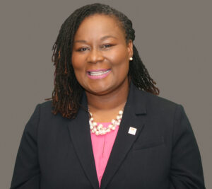 Valarie Fleming headshot, woman with black hair, black suit jacket, pink shell, pearl jewelry