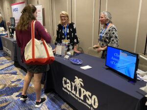 An attendee talking to the representatives at the CALIPSO booth at the 2024 Welcome Reception.