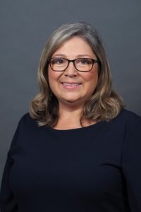 Catherine Cooper headshot, white female, shoulder length gray hair, black blouse