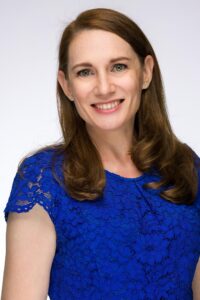 Patricia Geels headshot, white female, long brown hair, royal blue blouse