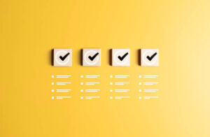 Alternative Grading Checklist, task list, to do, work time confirmation check, or quality control. Goals achievement for business success. Check marks icons on wooden blocks and jobs list symbols on a yellow background.