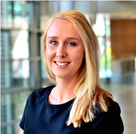 Woman with below the shoulder straight, blonde hair, smiling, wearing navy blue blouse