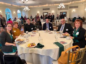group of people smiling around a table