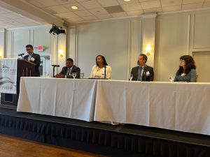 speakers sitting on stage at table