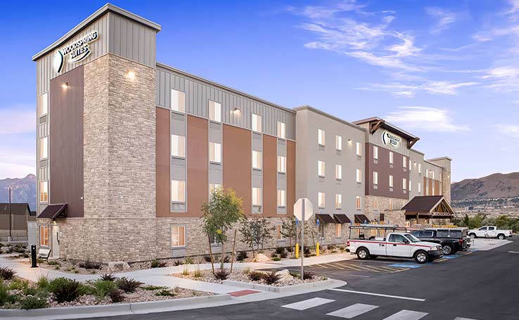 WOODSPRING-SUITES-BLUFFDALESLC-EXTENDED-STAY-HOTEL-EXTERIOR-DUSK-738X456