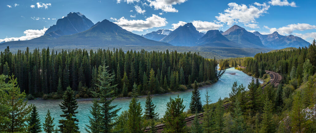 Iconic view of Morants Curve where the Canadian Pacific Railway runs along the stunning Bow River with the beautiful Canadian Rockies in the background, Banff National Park, Alberta, Canada