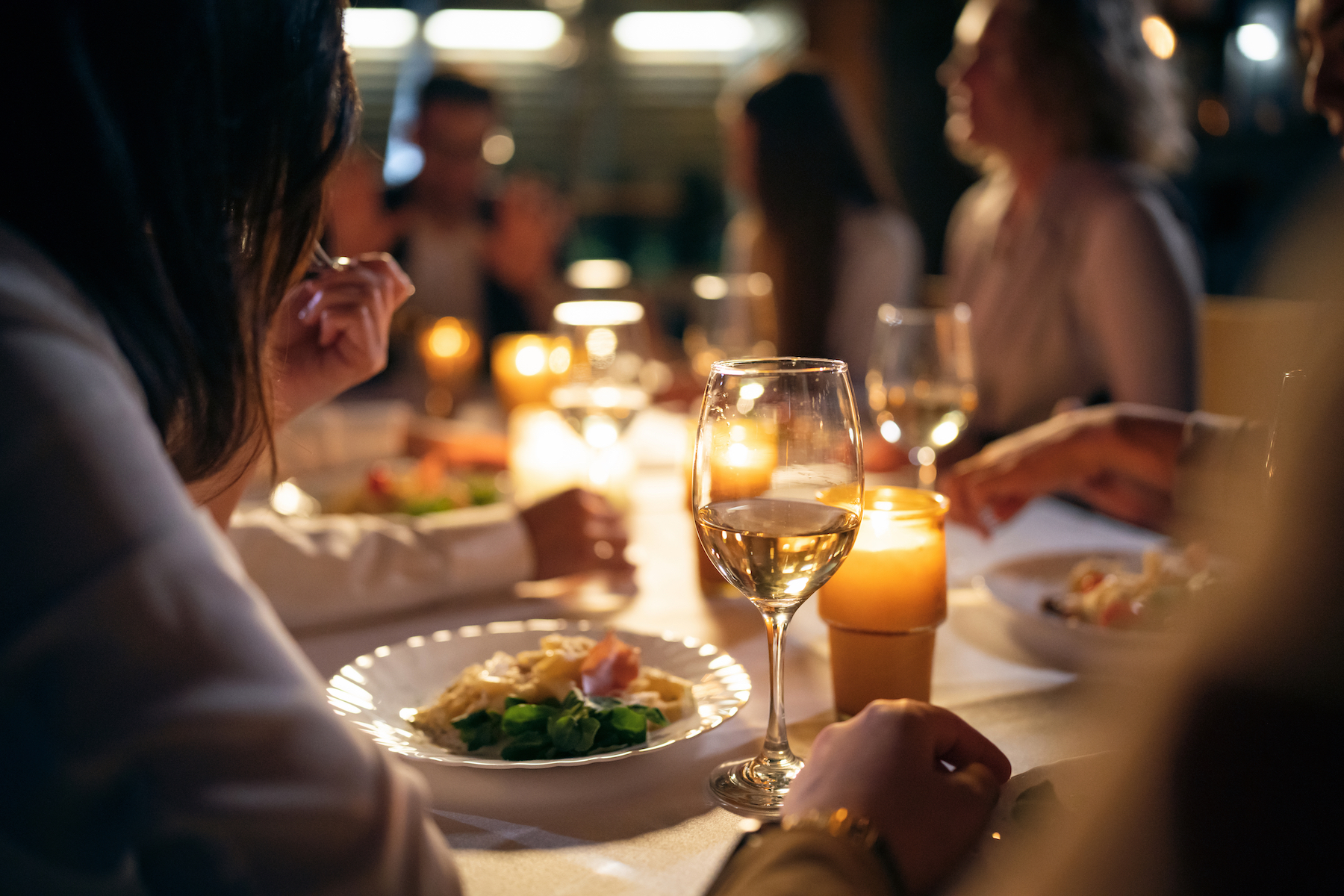 Group of multiracial female and male friends, having the dinner at the restaurant balcony