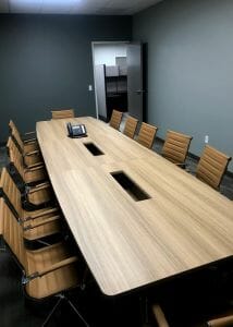 A neat and clean office room with a long office table and chairs for 10 people to sit at