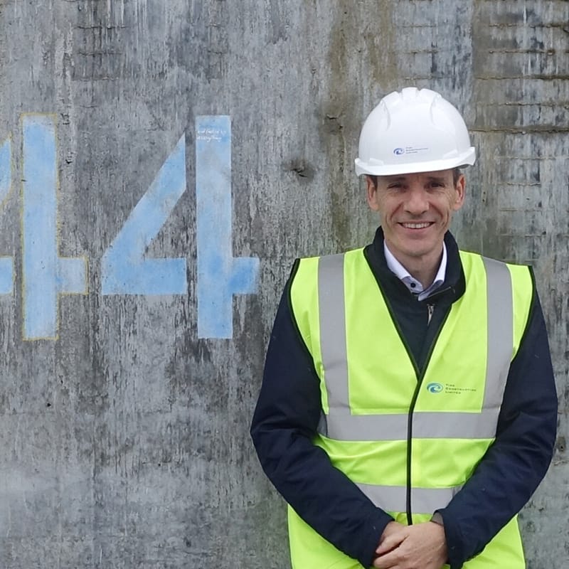 Michael Hough, diretor da MJH Structural Engineers, ao lado do núcleo da 101 George Street em Londres, um projeto modular volumétrico de arranha-céus que ele e sua equipe projetaram. Crédito da foto: Michael Hough.