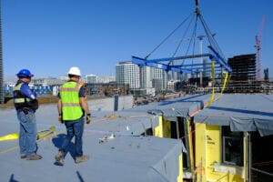 Un equipo de decorado coloca parte de un edificio modular volumétrico