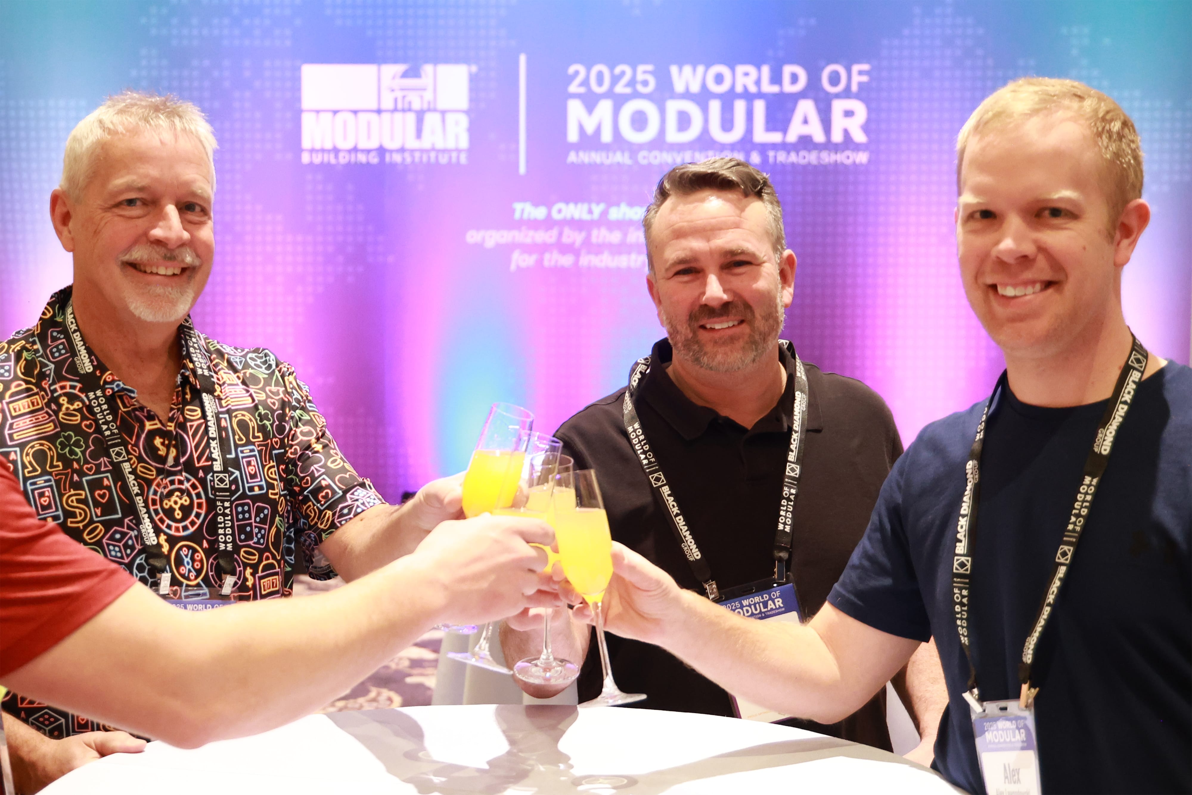 Image of attendees clinking glasses around a cocktail table