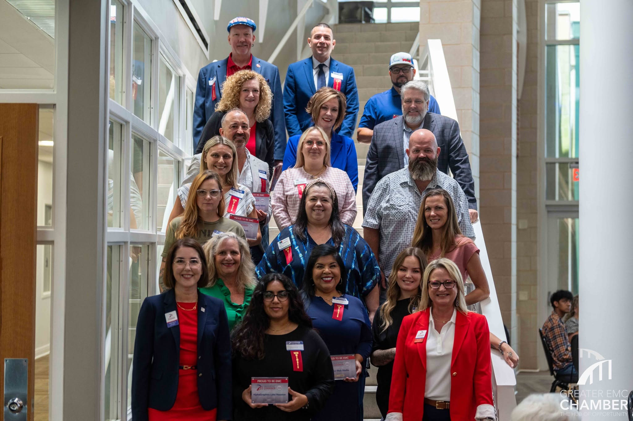 05_NewMembers New members proudly display their membership plaques on the stairs of The Atrium Center.