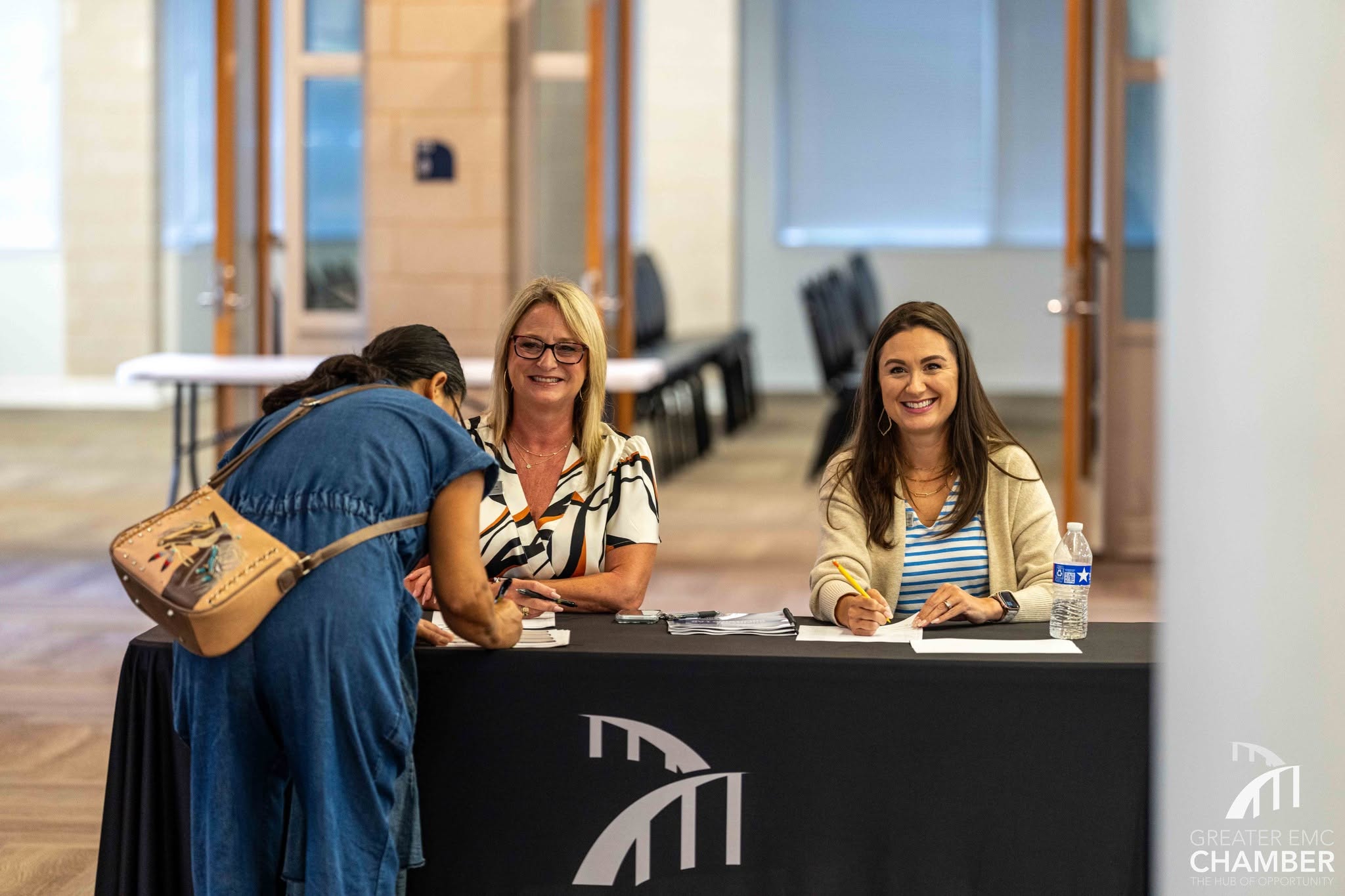 Cheri Grebe, Vice President of Member Opportunities, and Tracie Kamenoff, Director of Events &amp; Marketing for the Greater EMC Chamber check in event attendees