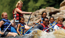 Group of adults and kids whitewater rafting on Lehigh Gorge River.