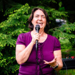 Woman in magenta shirt talking into microphone