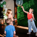 Three children playing with balloons