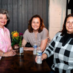 Three woman drinking water at a table