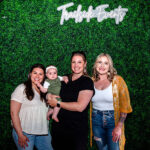 Three women posing with baby