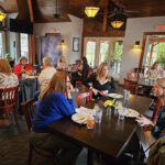 Ladies talking at dining table inside Nick's Lake House Restaurant