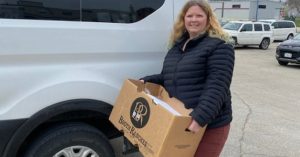 North Iowa Community Action staff member carries box of CACFP foods