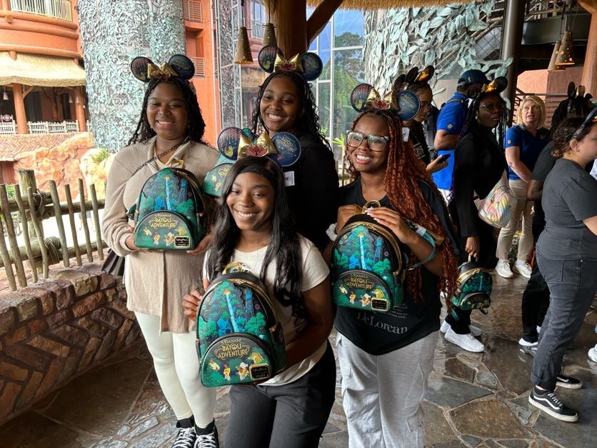 4 African American girls wearing Disney Mickey Mouse Ears Carrying a Black Disney Backpack