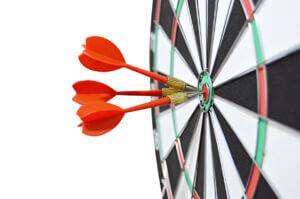 red, black, white, green , red, target board with 3 red darts hitting the bullseye