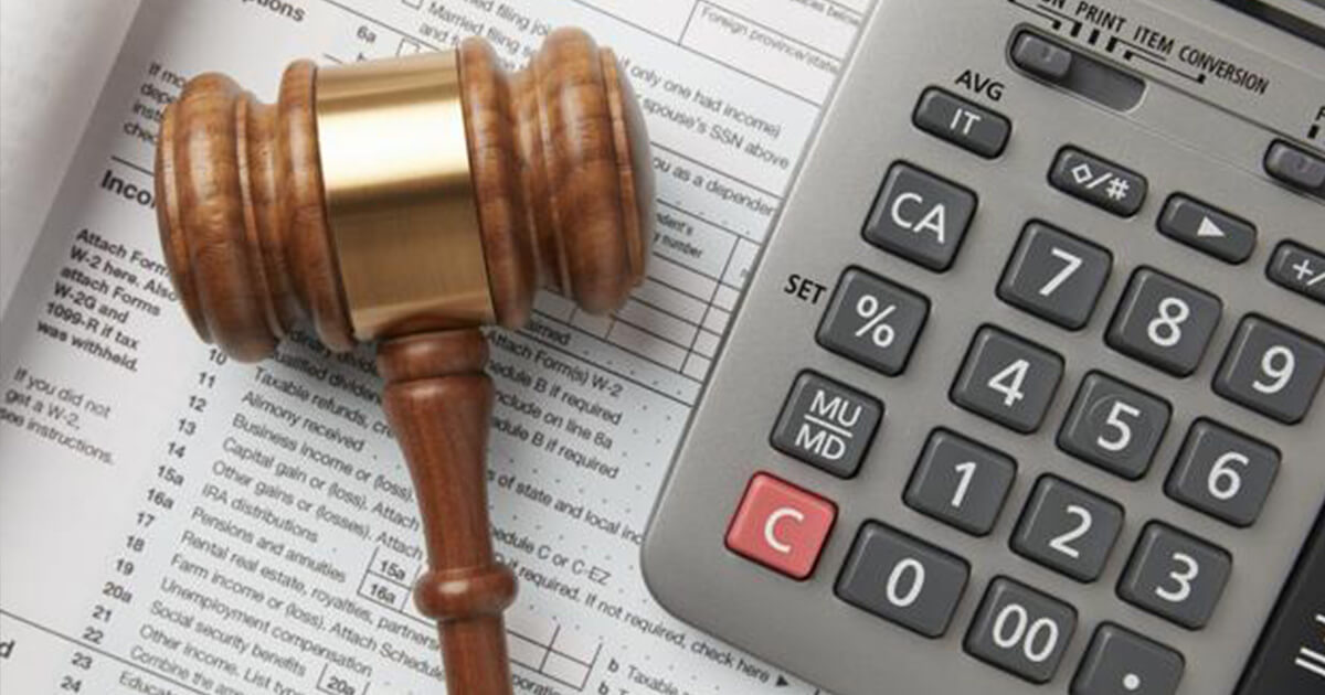 tax Wooden gavel and calculator on a tax form.