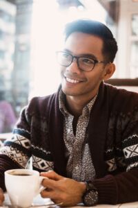 man-smiles-over-coffee-in-cafe