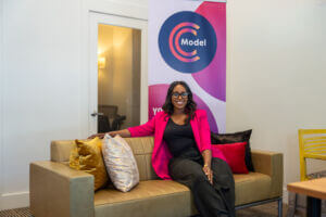 Photo of CModel Co-Founder Teasha Cable sitting on the couch in front of her office