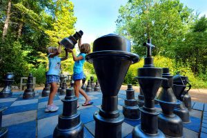 2 children playing with lifesize chess peices