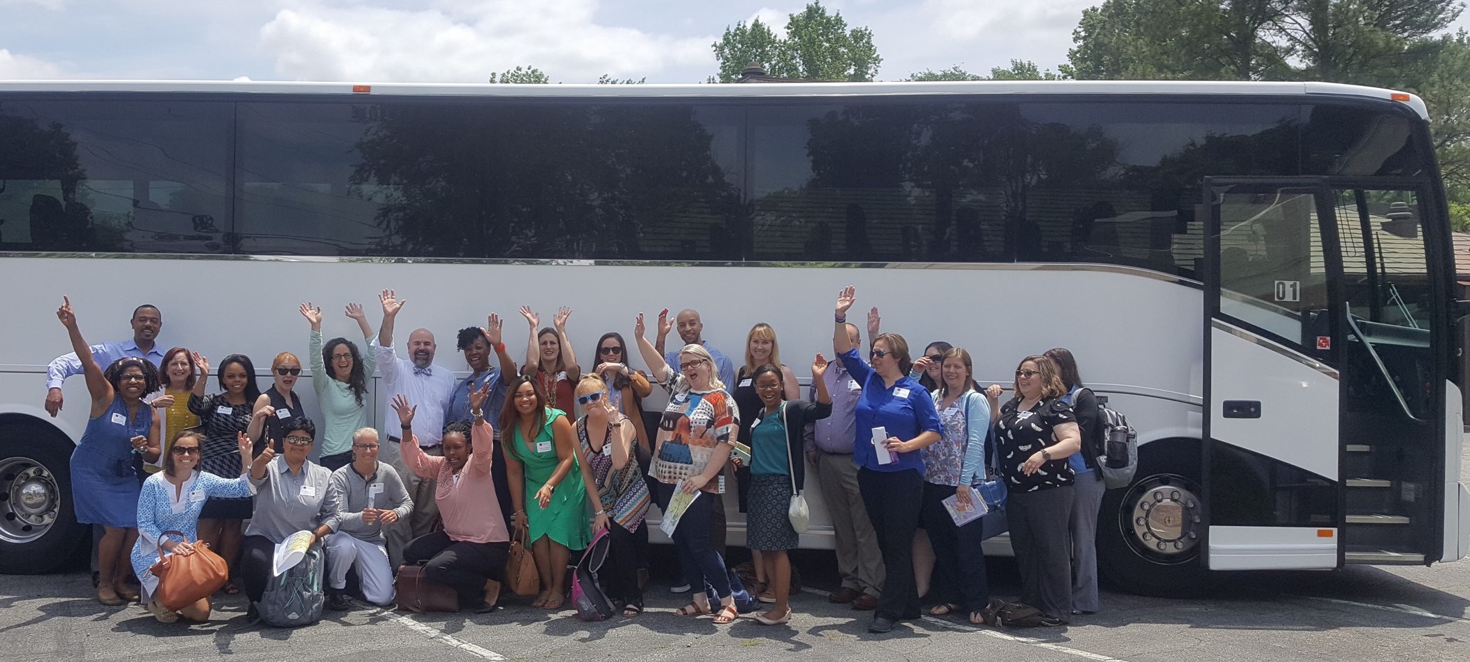 leadership group in front of coach bus