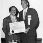 Eugene Garfield (l) receiving 1975 Award of Merit from Dale Baker (r)