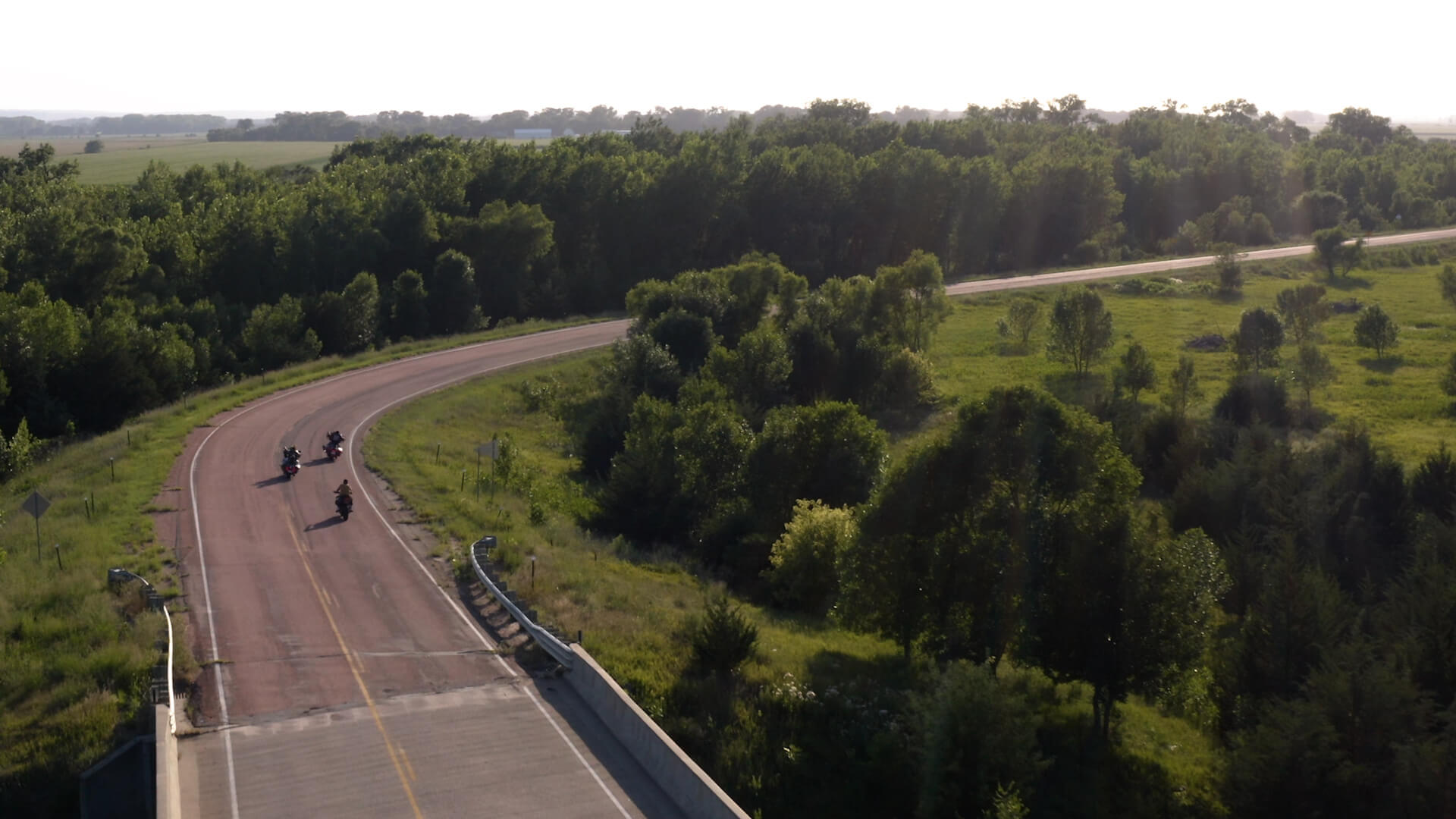 Three bikers ride into Vermillion on a winding road.