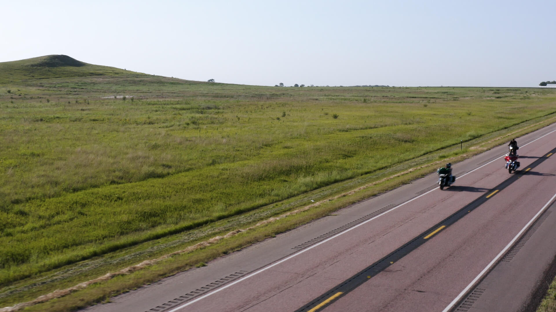 Three bikers ride by Spirit Mound.