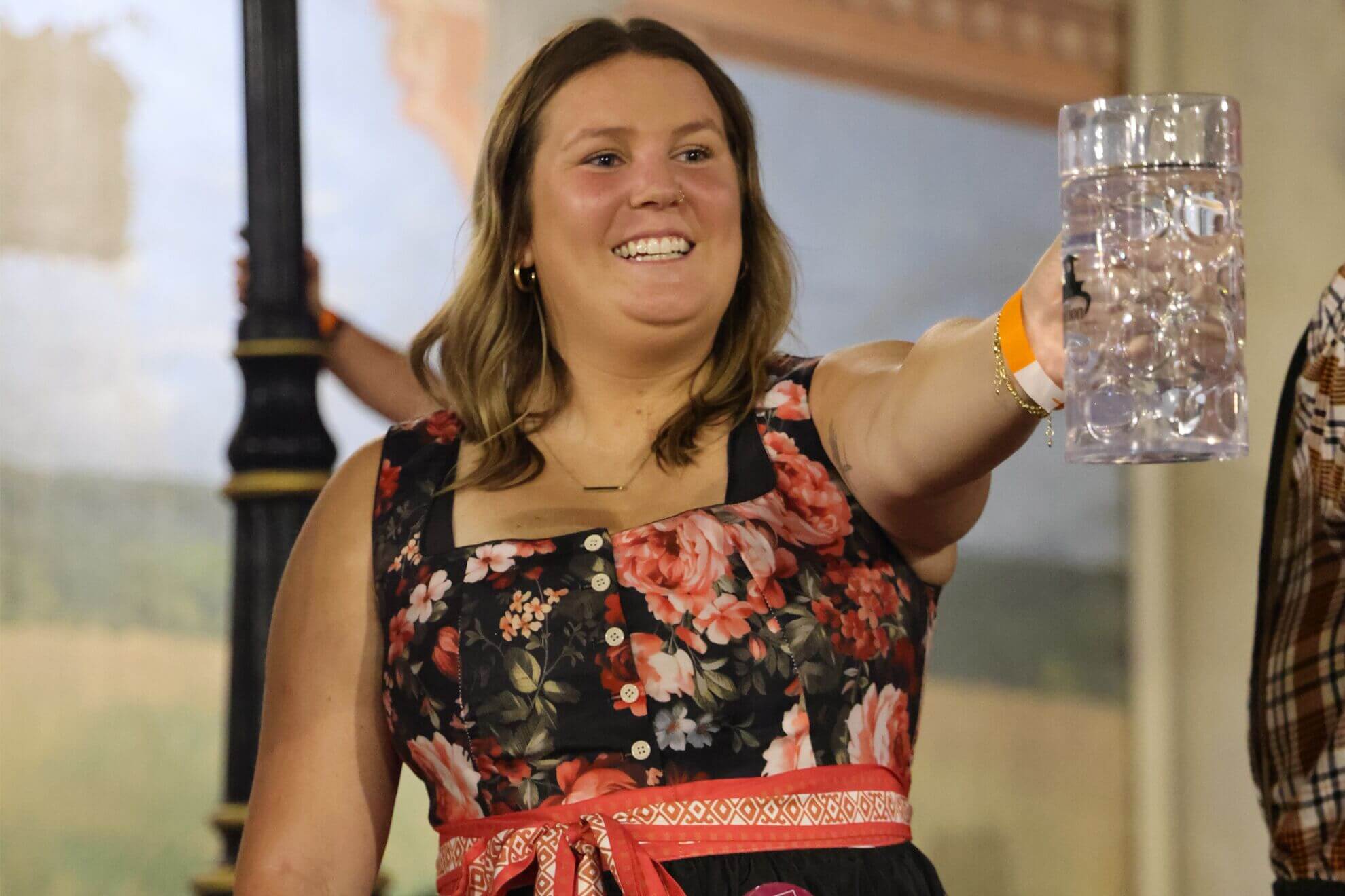 A woman wearing a dirndl holding a stein in the stein hoisting competition