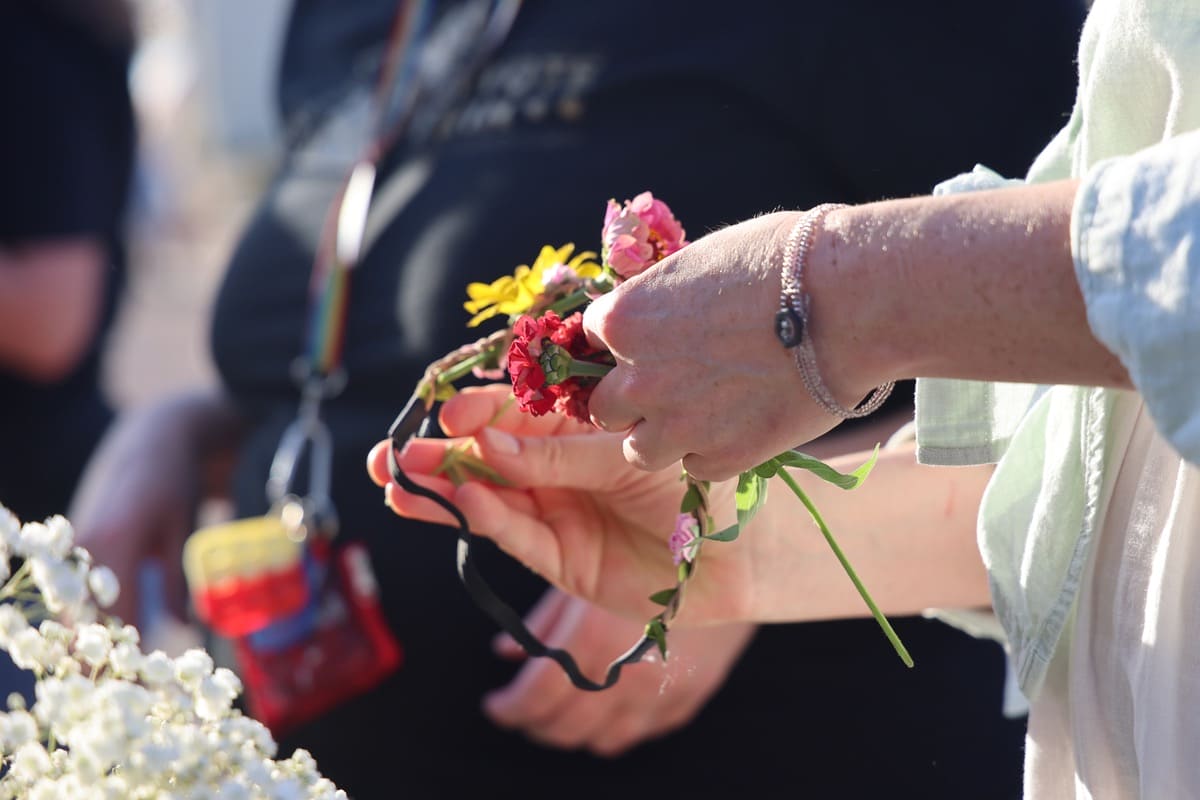A close-up shot of someone's hands making a flower crown.