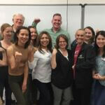 A group of individuals in the nonprofit sphere who participated in one of UNA's credential classes, flexing their arms.