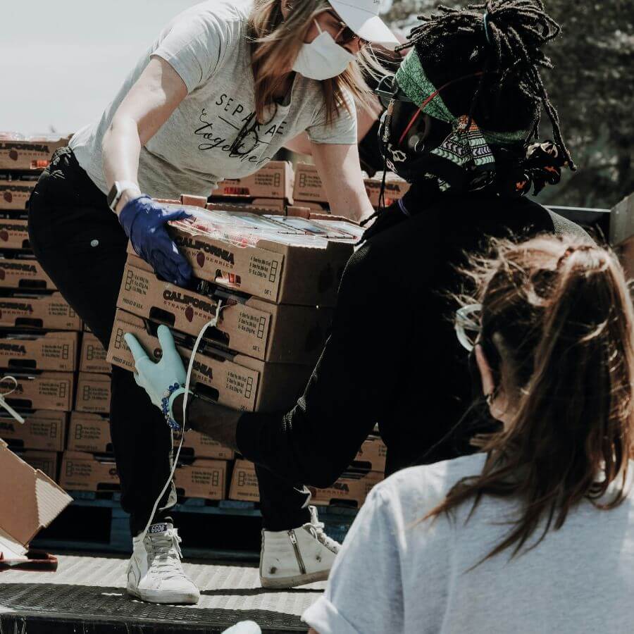Volunteers working to unload a truck full of cardboard boxes.