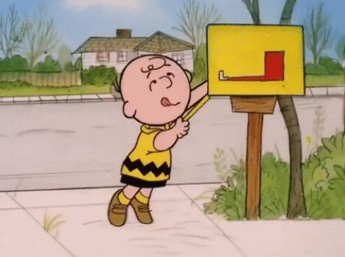 Charlie Brown reaching into a mailbox.