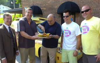 Town of Milton Supervisor Dan Lewza helps steady the plate as Ballston Spa Mayor John Romano cuts the ceremonial cheeseburger Wednesday to promote this weekend’s Parrot Head Festival at the Saratoga County Fairgrounds and its accompanying Jimmy Buffet-themed events in the village of Ballston Spa. Saratoga County Chamber of Commerce President Todd Shimkus and festival promoters Garth Ellms and A.J. Bodden looked on at The Factory in Ballston Spa. (ED BURKE/eburke@saratogian.com)